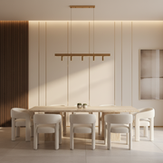Modern dining room with a long wooden table and white chairs, featuring a pendant light fixture.