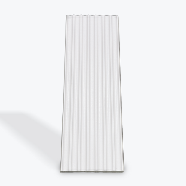 Rectangular white ceramic plate with ribbed texture on a light gray background